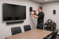 Configuración de audio envolvente o barras de sonido en salas y oficinas.
un tecnico formal con camisa polo manga corta instalandolo, el taladro que no apunte a la tv